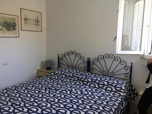 a bed with a blue and white comforter in a bedroom at L'Isolana Case Vacanza Villa Alessia in Ponza