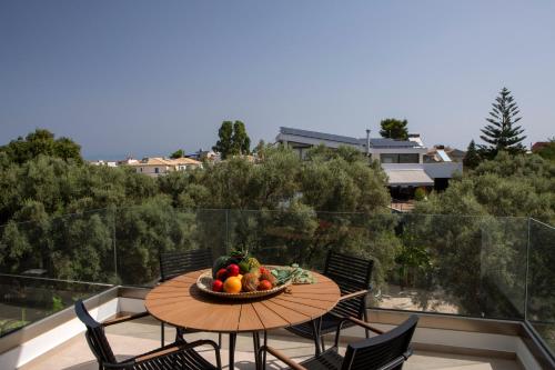a table with a bowl of fruit on a balcony at ELFAM CITY SUITES in Lefkada Town