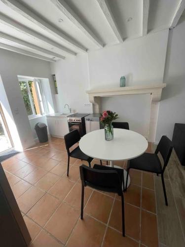 une salle à manger avec une table et des chaises blanches dans l'établissement Charmante maison à la campagne, à Sainte-Fauste