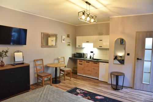 sala de estar con cocina con mesa y sillas en Hoffman Apartament, en Cracovia