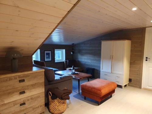 ein Wohnzimmer mit einem Schreibtisch, einem Stuhl und einem Tisch in der Unterkunft Ski in-out at Lifjell-Mountain cabin with majestic views close to Bø Sommarand in Bø