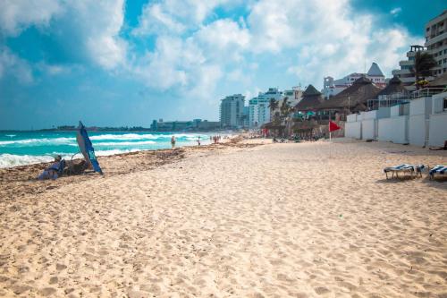 a sandy beach with an umbrella and the ocean at Rodero by Solymar Beach Front Condos in Hotel Zone in Cancún