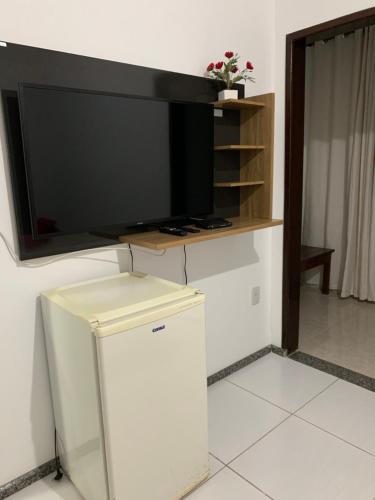 TV de pantalla plana en la pared de una habitación en Pousada Portal da Chapada, en Rio de Contas