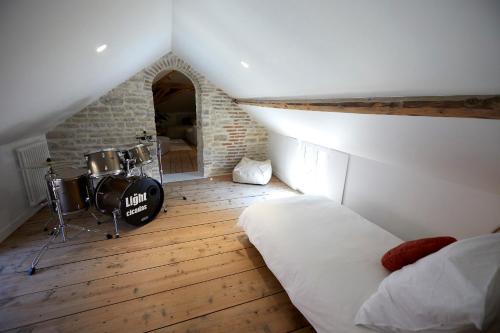 a room with a bed and drums in a attic at Couette&Living - Maison design à Savigny-les-Beaune in Savigny-lès-Beaune