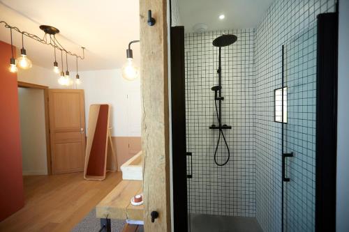 a bathroom with a shower with blue tiles at Couette&Living - Maison design à Savigny-les-Beaune in Savigny-lès-Beaune