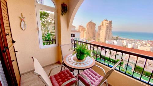a balcony with a table and chairs and a view of the ocean at Beautiful apartment near LaMata Beach with PANORAMA SEA view!!! in Torrevieja
