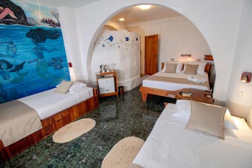 a room with two beds and a painting on the wall at Hotel Casa Blanca in Puerto Baquerizo Moreno