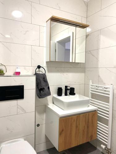 a white bathroom with a sink and a mirror at Elegance Self check-in Free Parking in Tuzla