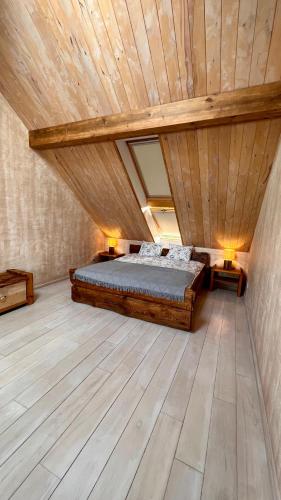 1 dormitorio en el ático con 1 cama y techo de madera en Kapteinis Āķis apartamenti en Ulmale