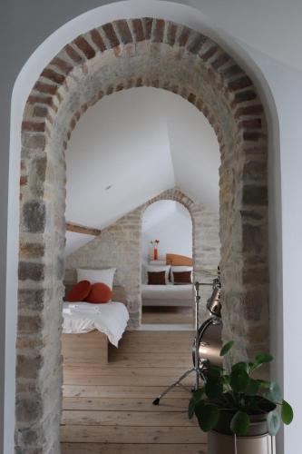 an archway in a room with a bed and a bedroom at Couette&Living - Maison design à Savigny-les-Beaune in Savigny-lès-Beaune