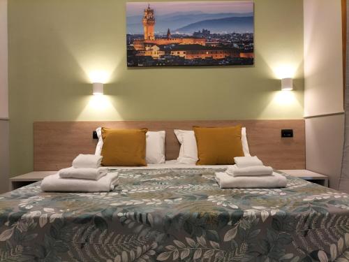 1 dormitorio con 1 cama grande y toallas. en Hotel Camilla Guelfa en Florencia