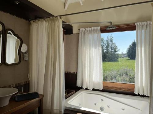 een badkamer met een bad en een raam bij Casa de campo en club privado in San Miguel del Monte