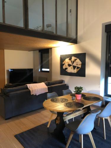 ein Wohnzimmer mit einem Tisch und einem Sofa in der Unterkunft Superbe Duplex rénové avec vue exceptionnelle sur Lyon in Lyon