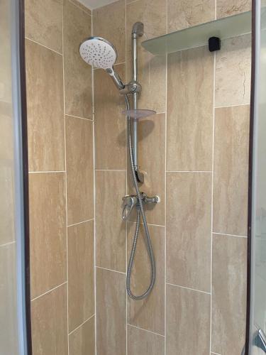 a shower with a shower head in a bathroom at 2nd floor Enfield town studio flat in Enfield