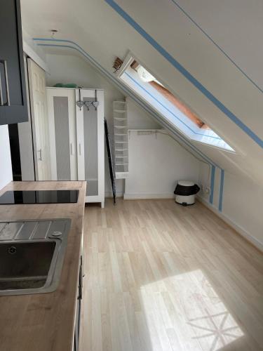 um quarto vazio com uma cozinha e um loft em 2nd floor Enfield town studio flat em Enfield