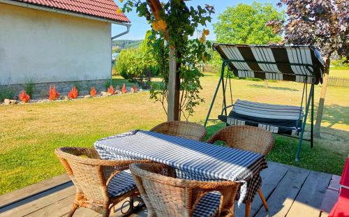 a table and chairs on a porch with a grill at Old Style Cottage in Horní Paseka