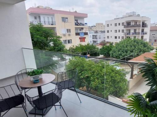einen Balkon mit einem Tisch und Stühlen sowie Aussicht in der Unterkunft New Smart Living-1 Bedroom Aglantzia, Nicosia in Aglantzia