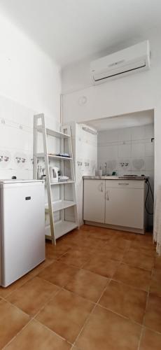 eine Küche mit weißen Schränken und einer Leiter in einem Zimmer in der Unterkunft ELLE in Rovinj