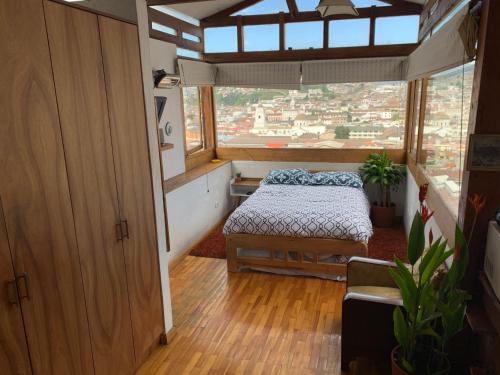 a bedroom with a bed and a large window at Quito Downtown View Point Studio in Quito