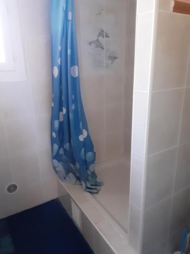 une salle de bain avec une douche avec un rideau de douche bleu dans l'établissement Mihechris, à Collioure