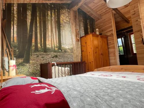 ein Schlafzimmer mit einem Bett in einer Holzhütte in der Unterkunft Le chalet du Hélivy in Jalhay