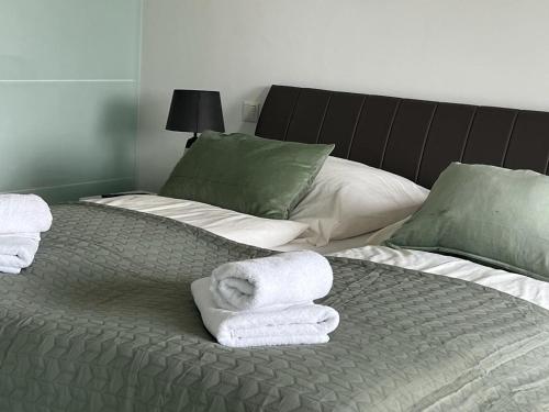 Una cama con toallas y almohadas encima. en Pearl 7 Nordsee Park Dangast, en Dangast