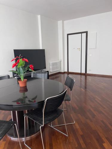 uma mesa preta com cadeiras e um vaso com flores em Corso Vittorio Apartment em Bari