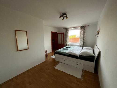 a small bedroom with a bed and a window at Apartmán MW in Poprad