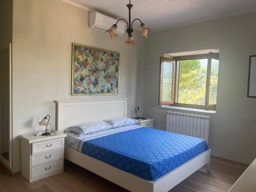 um quarto com uma cama com um edredão azul em Green Deluxe Apartment “La locanda del Borgo” em San Donato di Ninea