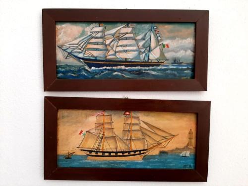 twee ingelijste schilderijen van een schip in de oceaan bij Casa Francesca, vicino al mare in Sestri Levante