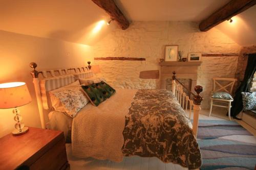 a bedroom with a bed and a table with a lamp at Gorgeous romantic cosy cottage retreat with views in Winster