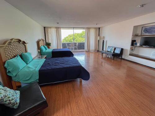 a large room with two beds and a living room at Suites Las Plazas in Cuernavaca