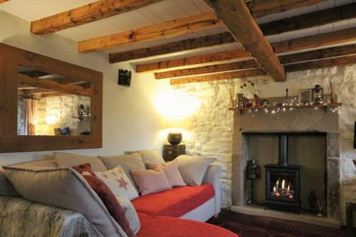 a living room with a couch and a fireplace at Gorgeous romantic cosy cottage retreat with views in Winster