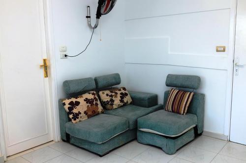 a green couch and a chair in a room at Spring Hotel Luxor in Luxor