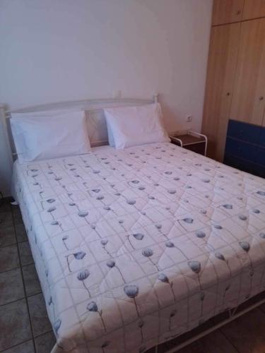 a bedroom with a bed with a white bedspread at Kali’s casa in Karavomylos