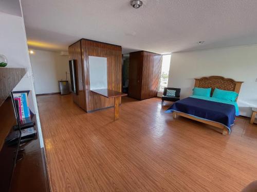 a bedroom with a bed with blue pillows on it at Suites Las Plazas in Cuernavaca