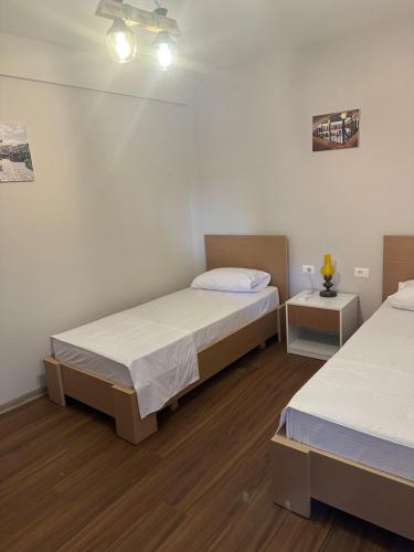 um quarto com duas camas e uma mesa de cabeceira com duas mesas em Vila Alba em Korçë