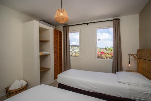 1 dormitorio con 2 camas y ventana en Casa Pacifico, en Willemstad