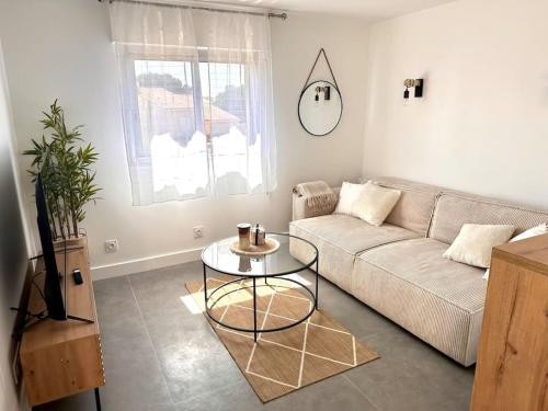 uma sala de estar com um sofá e uma mesa em Sérénité - Superbe Terrasse et Jacuzzi ! em Canet-en-Roussillon