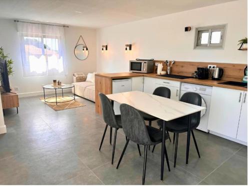 a kitchen and living room with a table and chairs at Sérénité - Superbe Terrasse et Jacuzzi ! in Canet-en-Roussillon