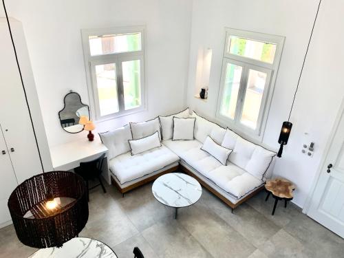 a living room with a white couch and two windows at Syboro in Aloïziánika