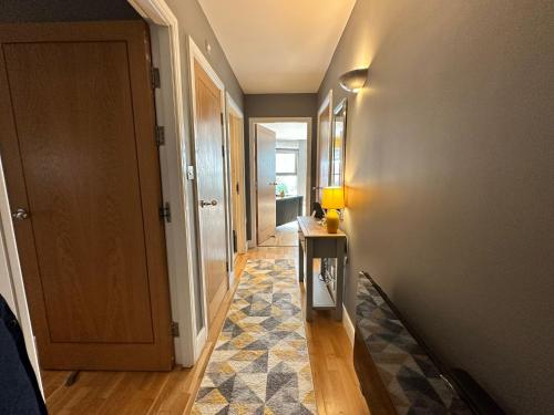 a hallway with a door and a rug on the floor at Fantastic and modern city centre flat with FREE parking! in Cardiff