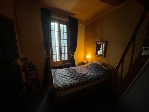 um pequeno quarto com uma cama e uma janela em À l'étape des jeunes randonneurs un adulte un enfant em Saignon