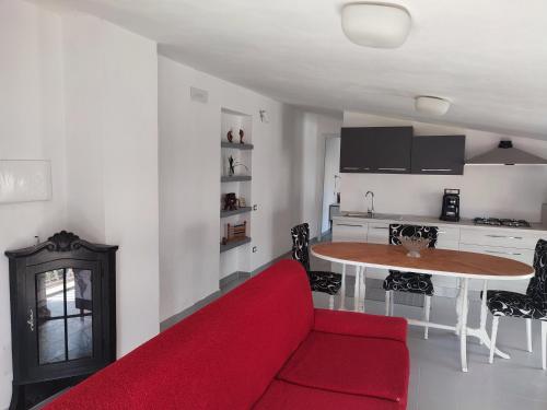 een woonkamer met een rode bank en een tafel bij La manSarda in Tortolì