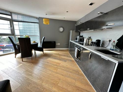 a kitchen and dining room with a table and chairs at Fantastic and modern city centre flat with FREE parking! in Cardiff