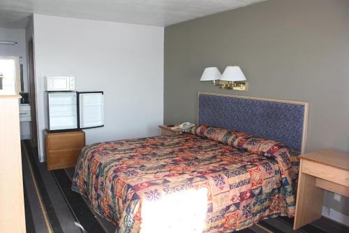 Lake Erie Lodge في Lakemont Landing: غرفة فندقية بسرير وطاولة ونافذة