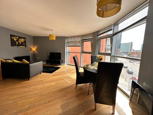 a living room with a table and a couch at Fantastic and modern city centre flat with FREE parking! in Cardiff