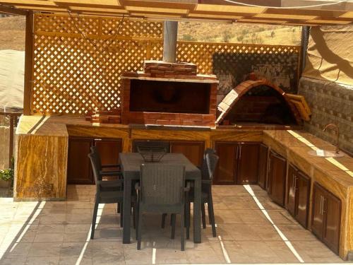 an outdoor kitchen with a table and chairs at Jarash farm in Jerash