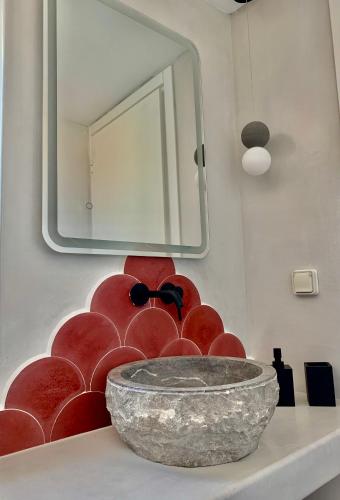 a bathroom with a mirror and a bowl on a counter at Syboro in Aloïziánika