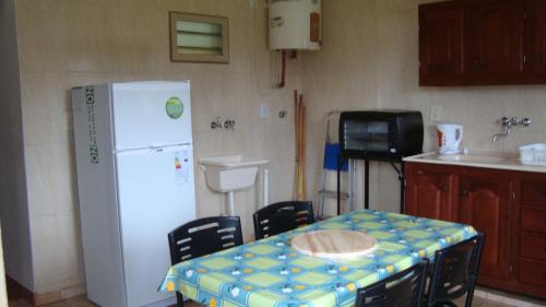 a kitchen with a table and a white refrigerator at Arai casa alquiler turistico in Oberá